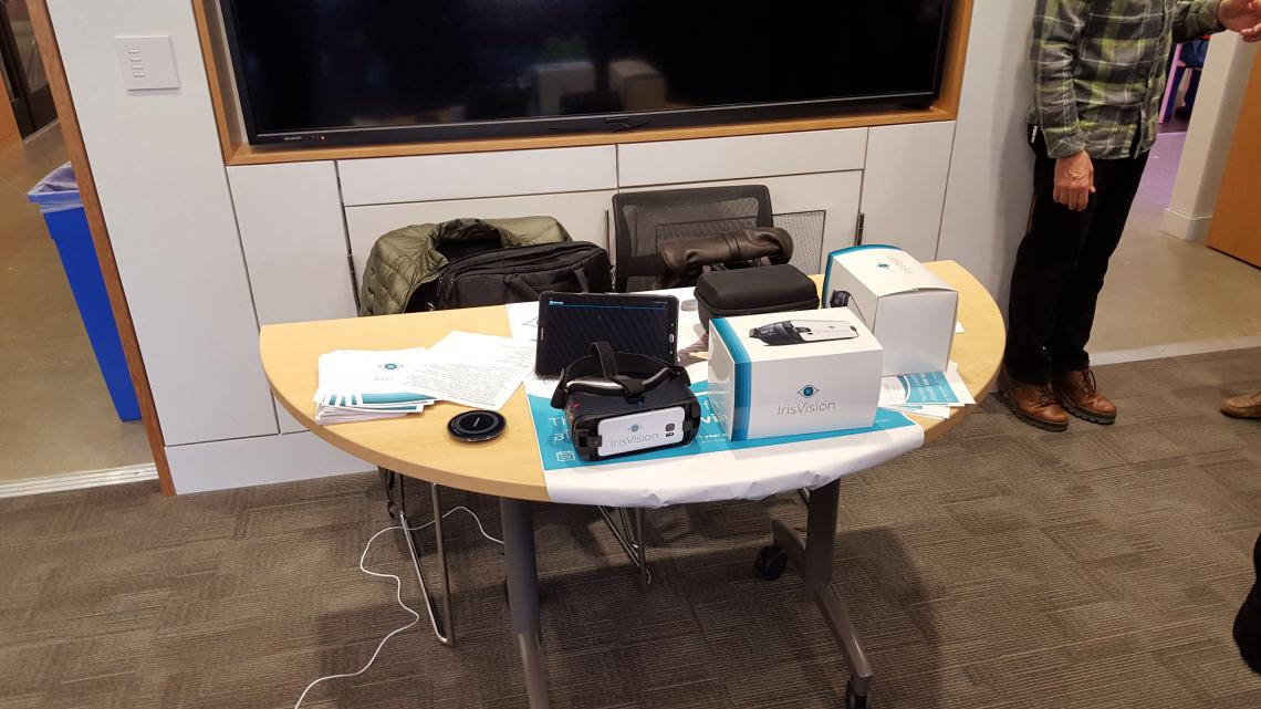 A table with Gear VR headset and Product packaging labeled "Iris Vision"